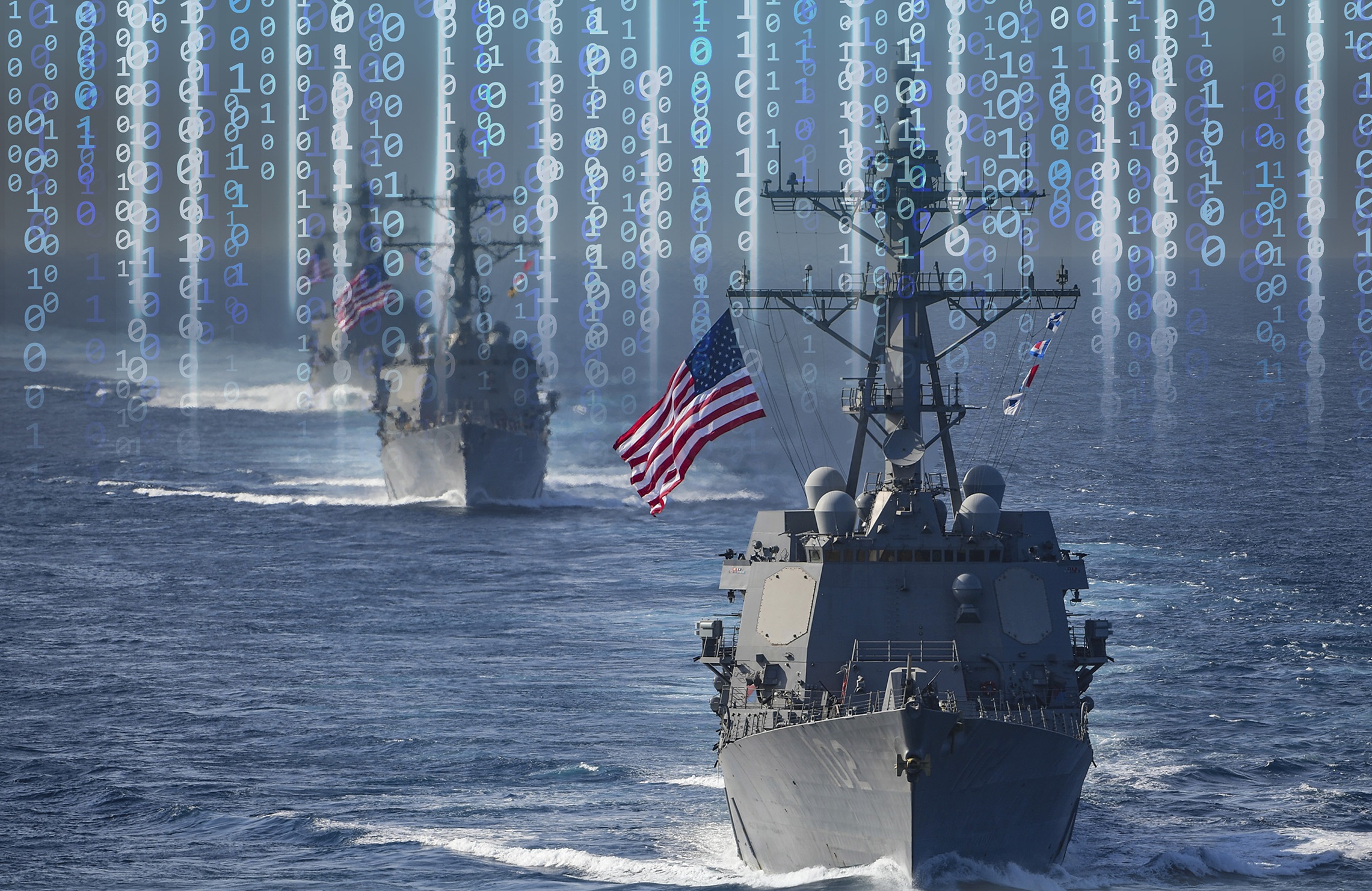 Two U.S. Navy ships at sea, the front ship waiving a U.S. flag