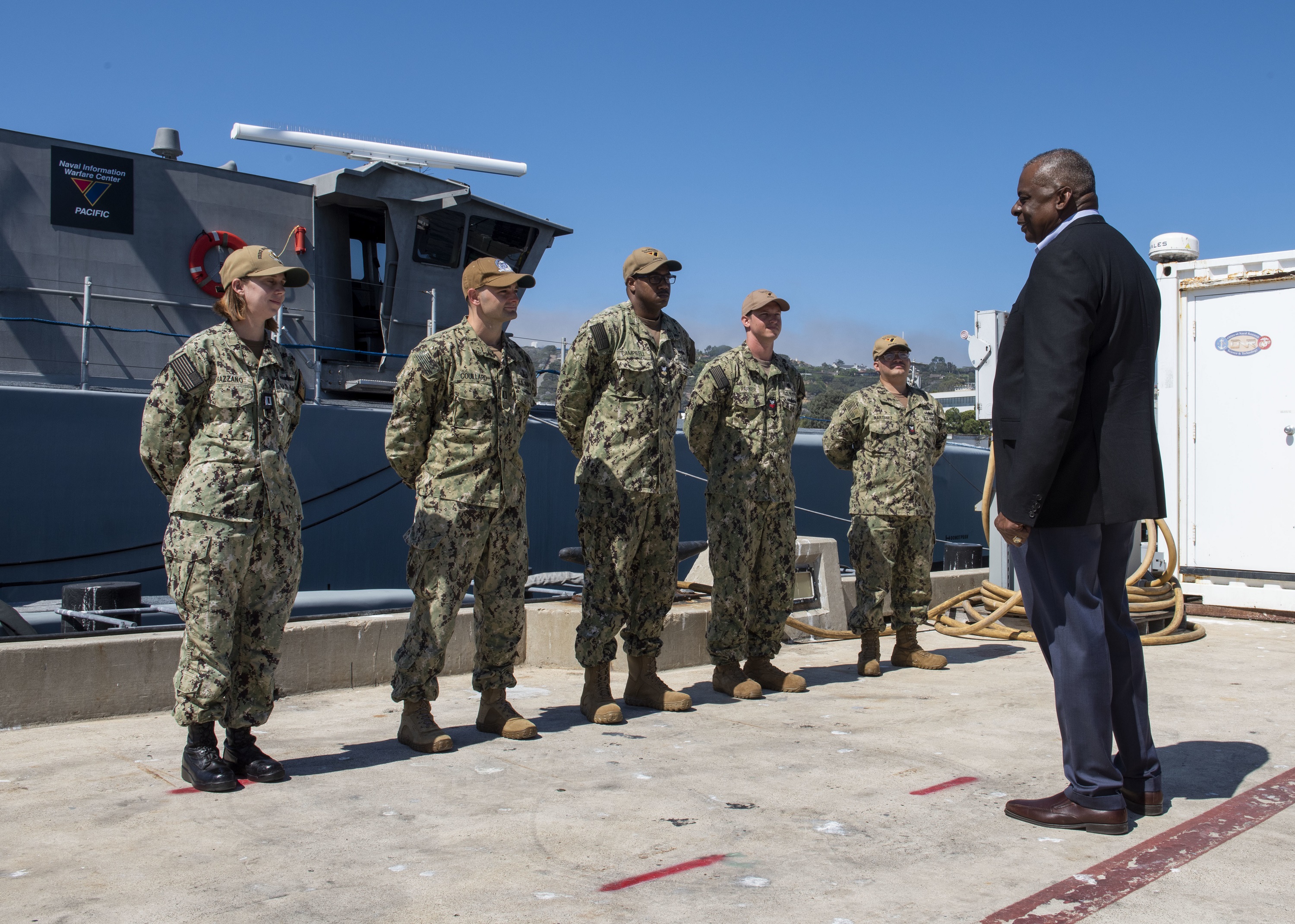 Five U.S. soldiers are greeted by a visitor in a suite