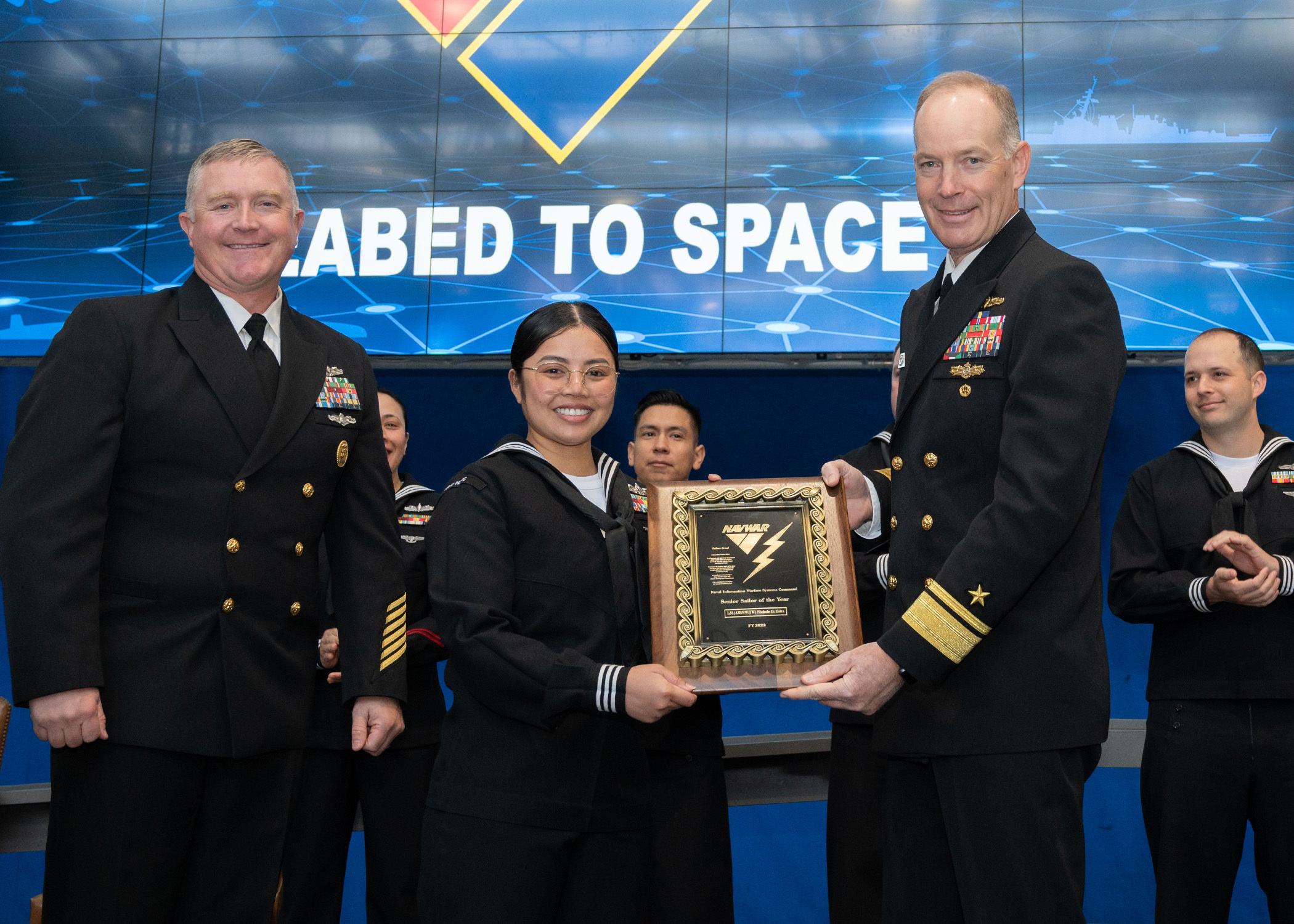 A female navy soldier receives an award at an awards ceremony
